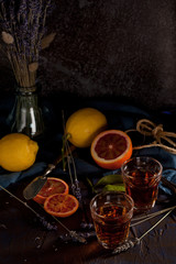 Rustic still life with tea or liqueur drink, citruses and lavender