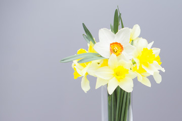 Posy of bright yellow daffodils on white wooden table