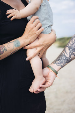 famille balade &agrave; la plage avec b&eacute;b&eacute; parents tatou&eacute;s