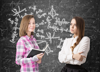 Fototapeta premium Two girls and formulas on blackboard