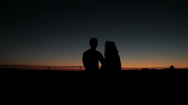 Silhouette couple kissing at sunset
