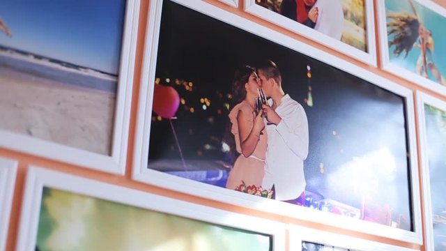 Close up of colorful photo on the wall at small room. peach background. Capture moments. Kissing at night