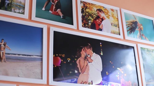 Close up of colorful photos and pictures on the wall at small room. peach background. Capture moments. Kissing at night