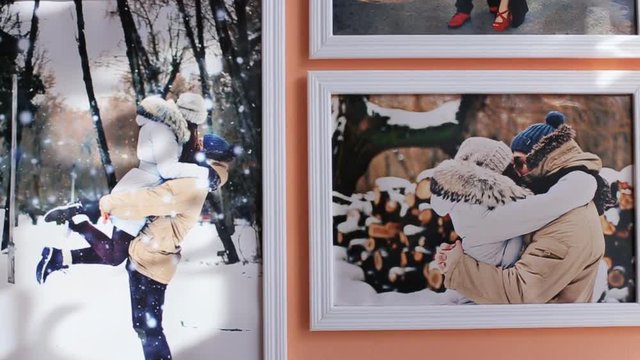 Close up of colorful photo on the wall at small room. peach background. Capture moments. Kissing and hugging in winter