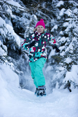 Fototapeta na wymiar A woman going for a run in snow shoes through snowy pine forest.