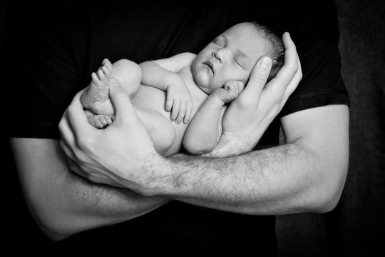 Newborn baby in the arms of the father