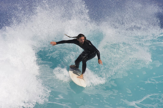 A Surfer rides a blue wave