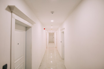Fototapeta na wymiar Corridor in a building. White staircase. Interior hallway with doors to the neighbors.