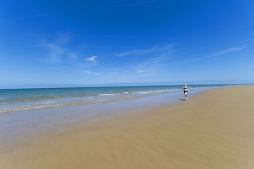 Fototapeta na wymiar Women Jogging along sandy beach.