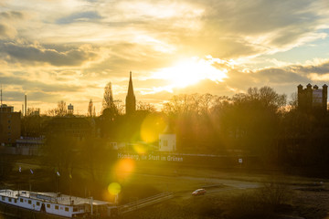 Fototapeta premium Silhouetted city with flares during sunset or sunrise
