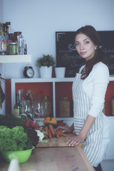 Young woman standing near desk in the kitchen
