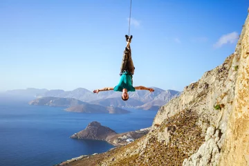 Foto op Aluminium Cheerful rock climber swinging on rope upside down © Andrey Bandurenko