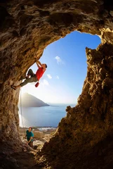 Tuinposter Rock climbers in cave © Andrey Bandurenko