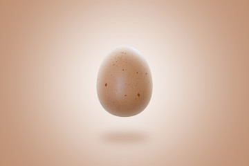 Isolated fresh brown egg flying in the air on a beige background. Levitation concept. 