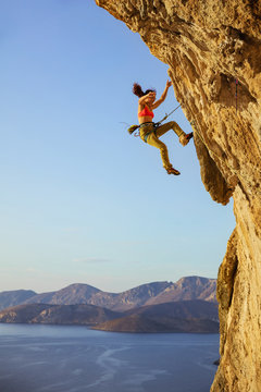 Female rock climber falling off cliff while lead climbing
