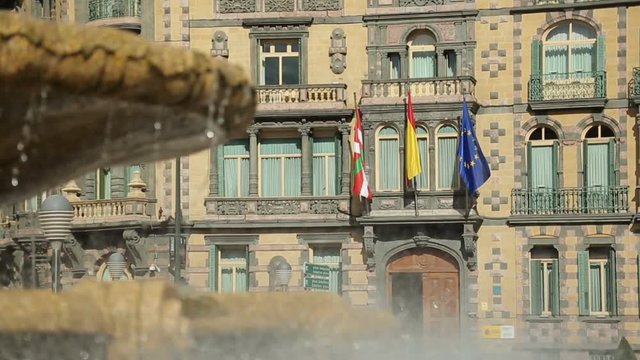 Basque, Spanish and EU flags flapping on Chavarri Palace facade in Bilbao center