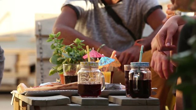 View of table with full of colorful cocktails and pizza