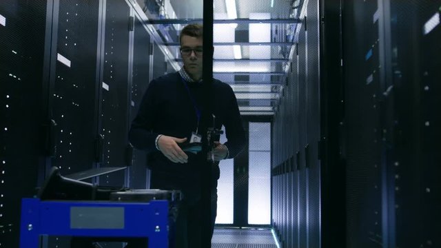 Server Engineer Changes Hard Drives in Open Cabinet of Rack Server. He's Works in Big Data Center. Shot on RED EPIC-W 8K Helium Cinema Camera.