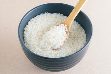 Rice in wooden spoon on bowl