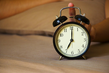 Finger is pressing alarm clock