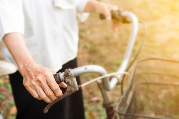 Women's Healthcare, older person hand holding bicycle - Powered by Adobe