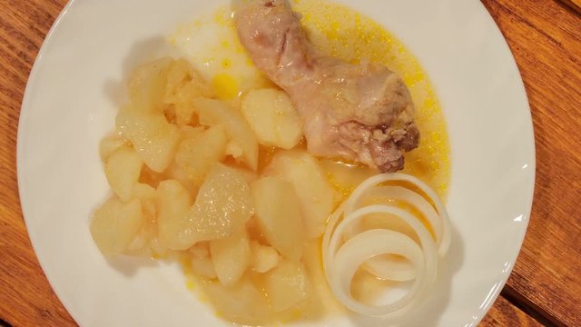 Potatoes and chicken legs in their own juice. Slow camera movement