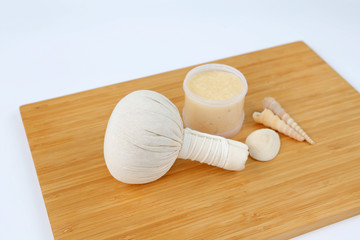 Fototapeta na wymiar Spa herbal compressing ball and Salt Scrub, Spa concept on bamboo board against white background