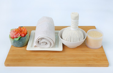 Spa herbal compressing ball with towels and Salt Scrub, Spa concept on bamboo board against white background