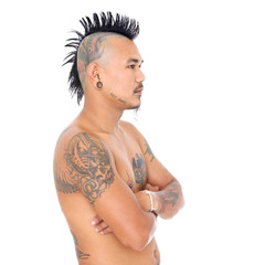 portrait of a mad asian punk guy with mohawk hair style, piercing and tattoo isolated on a white...