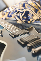 Fototapeta na wymiar Blue and black electric guitar on a bed.