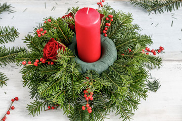 How to make christmas table centerpiece with fir, roses, balls and ilex twigs.