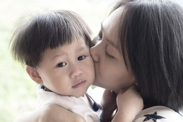 Young mother kissing her son