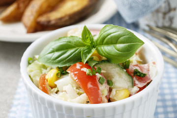 Vegetable salad decorated with basil leaf
