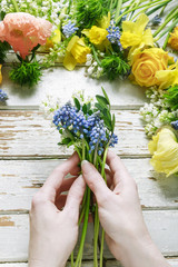 Woman arranging bouquet of springtime flowers.