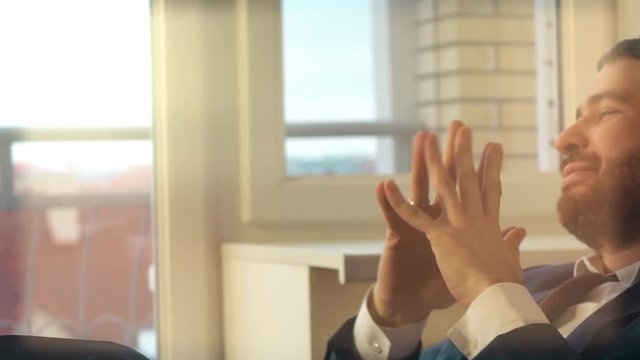 Young happy businessman having rest at his workplace. 4K video