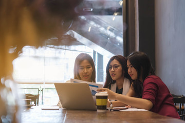 3 teenagers friends meet in coffee shop, using technology device  together