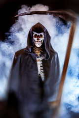 Fototapeta na wymiar ein Skelett mit Sense und im Umhang symbolisiert den Tod