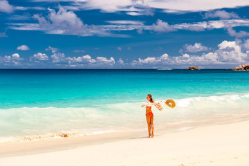Fototapeta na wymiar Woman with sarong on beach at Seychelles