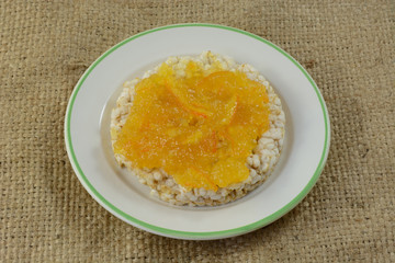 Orange marmalade in brown rice cake in plate