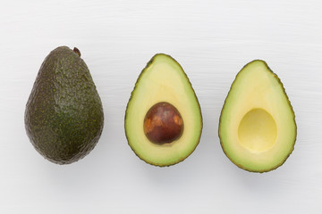Slices of avocado on white background. Whole and half with core. Design element for product label.