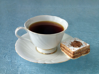 Tea in a porcelain cup and a biscuit cake