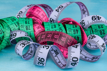 Colorful tapemeasure on blue background, close up
