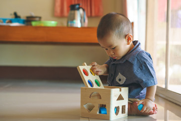 Asian baby playing wooden toy box
