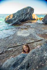 Beautiful woman boudering rock climbing on the shore