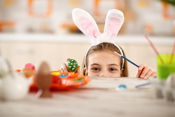 Girl with rabbit ears on head show colorful Easter egg