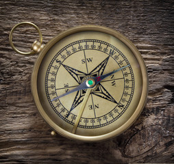 antique compass on grunge wooden background