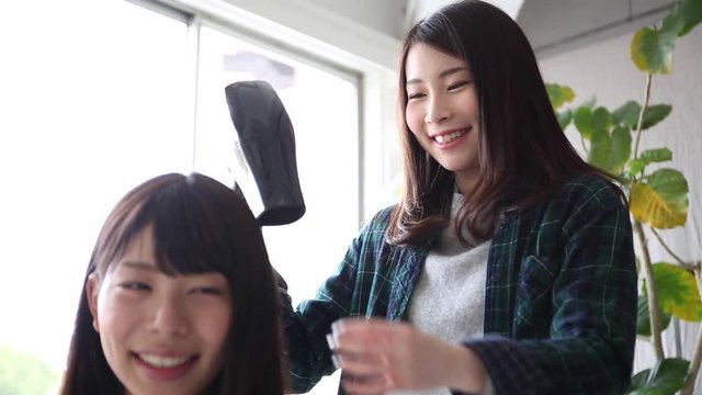 ドライヤーで髪を乾かす美容師