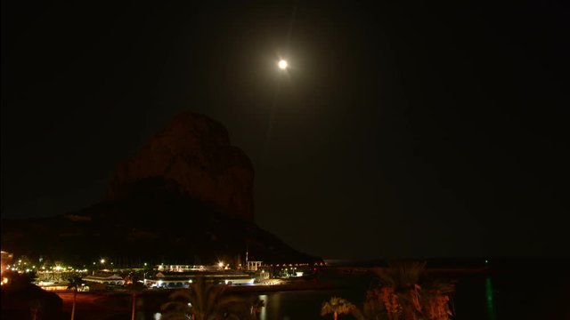 Rise of the moon over the mountain Penyal d'Ifach. Calpe. Spain. A rare event. The moon rises just above the top of the mountain Ifach. Time lapse.