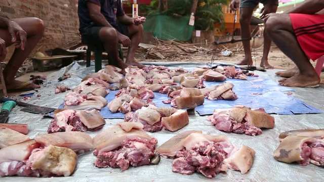 GOA, INDIA - 23 JANUARY 2015: Men preparing to weigh sorted meat.