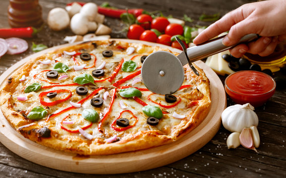 slicing pizza with pizza cutter.
